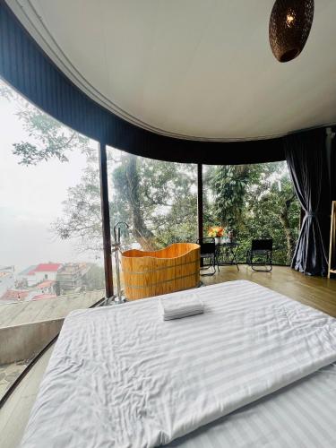 a large bed in a room with a large window at Tram Homestay - Venuestay in Tam Ðảo