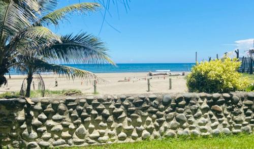 a stone wall in front of a beach at Quinta Duné Boutique - Un Paraíso Frente Al Mar in Chachalacas