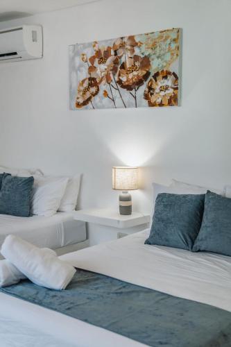 a bedroom with two beds and a painting on the wall at Casa Ceballos, Frente a la Playa in San Benito