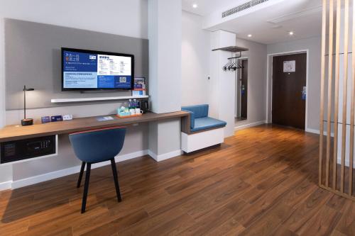 a room with a desk with a tv and a chair at Holiday Inn Express Zhoushan Dinghai by IHG in Zhoushan