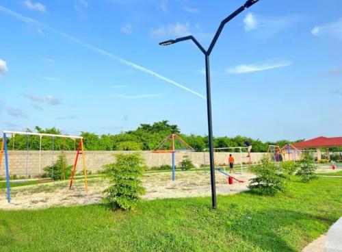 a playground with a light pole in the grass at Apartmento Xbox WFI TV65 PC Love Relax Work in La Cana