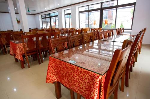 a dining room with tables and chairs and windows at Hòa Bình Tam Đảo Hotel in Tam Ðảo