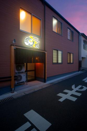 a building with a neon sign on the side of it at beppu turu 鶴 in Beppu