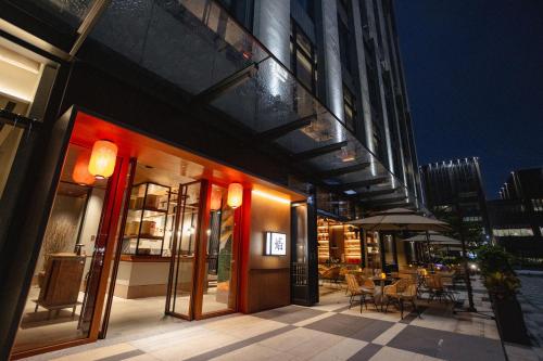 a restaurant with tables and chairs outside of a building at New World Guangzhou Hotel-- FREE Canton Fair Shuttle Bus in Guangzhou
