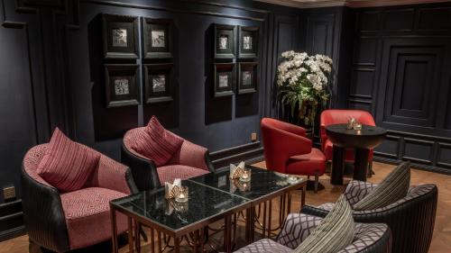 a living room with red chairs and a table at Champton Hanoi Hotel in Hanoi