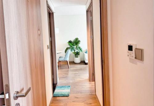 an open door to a hallway with a chair and a plant at A La Carte Ha Long Oceanview Fireworksview 2BR2WC suite with balcony in Ha Long