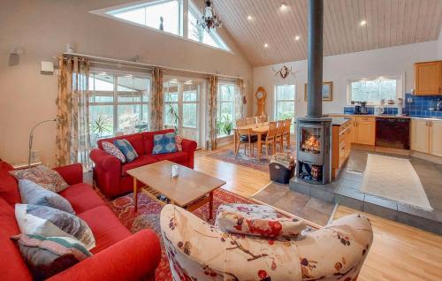 a living room with a red couch and a fireplace at Pet Friendly Home In Ullared With Sauna in Ullared