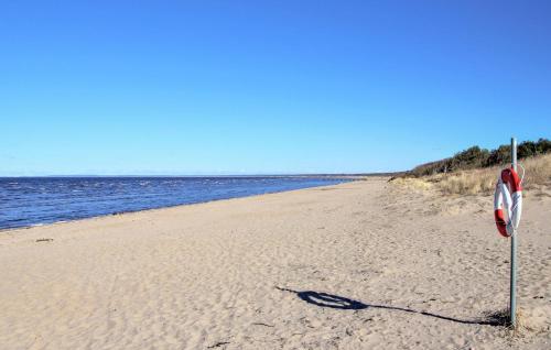 a beach with a sign in the sand and water at Beautiful Apartment In Falkenberg in Falkenberg