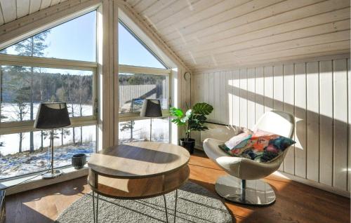 奥尔延Amazing Home In Årjäng With Lake View的客房设有桌子、椅子和窗户。