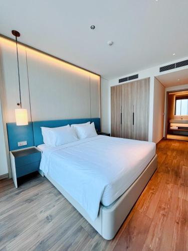 a bedroom with a large white bed in a room at A La Carte Ha Long Oceanview Fireworksview 2BR2WC suite with balcony in Ha Long