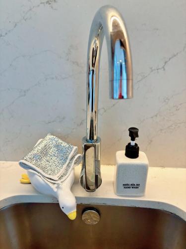 a sink with a faucet and a comb and a toothbrush holder at A La Carte Ha Long Oceanview Fireworksview 2BR2WC suite with balcony in Ha Long