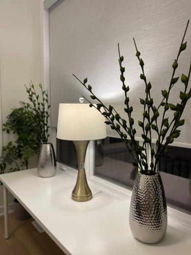 a table with a lamp and a vase with flowers at French Style Mansion In Prestigious Angus Glen Markham in Markham