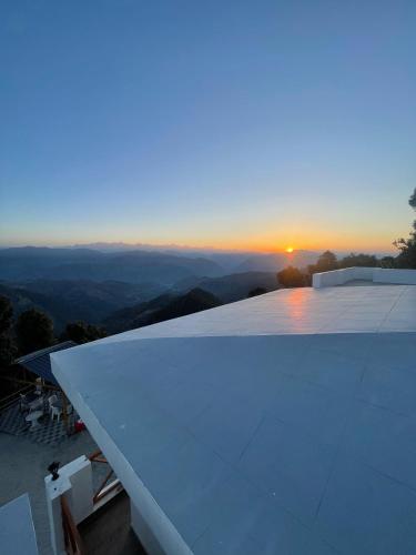 a view of the sunset from the roof of a house at Maatidera Resort Kanatal The Boutique stay in the Lap of Himalayas in Kanatal