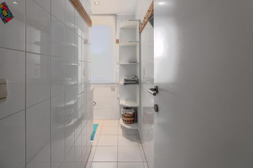 a white bathroom with white walls and a door at Juliette V4 P in Oostduinkerke