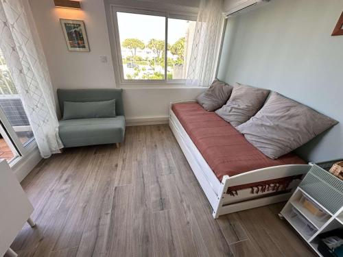 - un petit salon avec un canapé et une fenêtre dans l'établissement Bel appartement climatisé 2 pièces 4 personnes proche plage au Grau-du-Roi - FR-1-731-134, au Grau-du-Roi