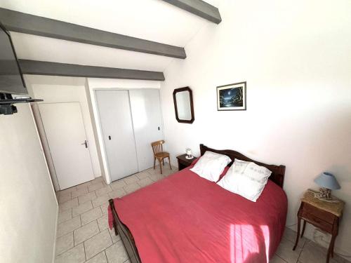 - une chambre avec un lit doté de draps rouges et d'oreillers blancs dans l'établissement Maison confortable 8 personnes avec jardin, Port-la-Nouvelle - FR-1-229C-105, à Port-la-Nouvelle