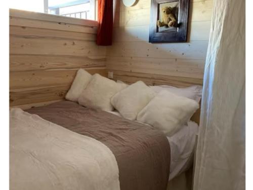 une chambre avec un lit avec des oreillers blancs dans l'établissement Appartement cosy avec Wi-Fi et parking privatif aux Gets - FR-1-671-288, aux Gets