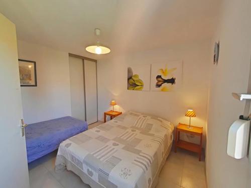 - une chambre avec un lit, deux tables et deux lampes dans l'établissement Appartement 2 pièces avec loggia vue mer, animaux admis - La Londe-les-Maures - FR-1-826-10, à La Londe-les-Maures