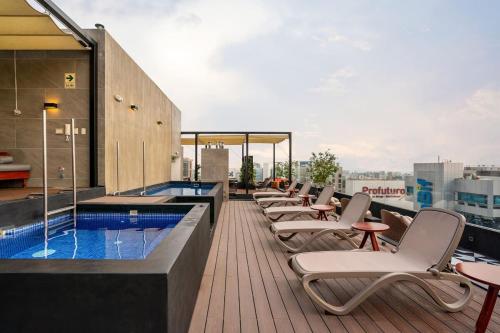 a row of lounge chairs and a swimming pool on a building at Alta Apartments by Geko in Lima