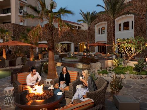 a group of people sitting around a fire pit at a resort at Grand Solmar Land's End Resort & Spa in Cabo San Lucas