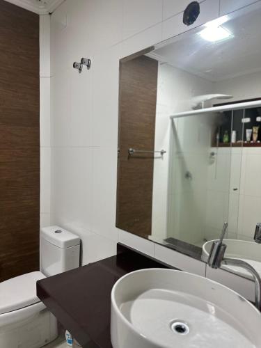 a bathroom with a sink and a toilet and a mirror at Casa Caborê, Paraty-RJ in Paraty