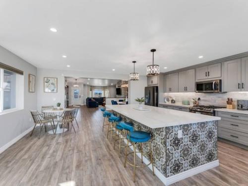 eine große Küche mit einer großen Insel mit blauen Barhockern in der Unterkunft Pickleball at 7000ft Private home with Court in Elden Pueblo