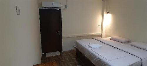 a small room with a bed and a television at Renny's Tangkoko Safety Stop in Bitung