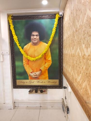 a picture of a man hanging on a wall at Aum Hotel in Puttaparthi