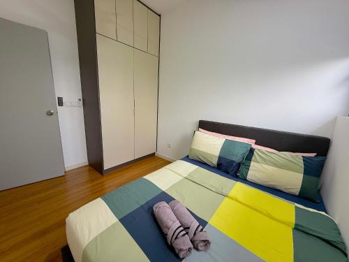 a bedroom with a bed with two slippers on it at M Vertica Cheras by RASBO Galaxy Suites in Kuala Lumpur