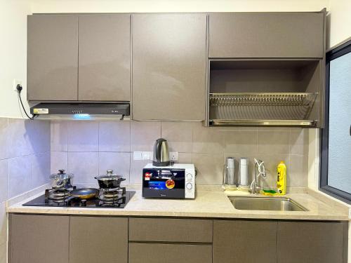 a kitchen with a sink and a stove top oven at M Vertica Cheras by RASBO Galaxy Suites in Kuala Lumpur