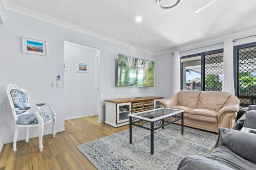 a living room with a couch and a table at Amity Place in Sandstone Point