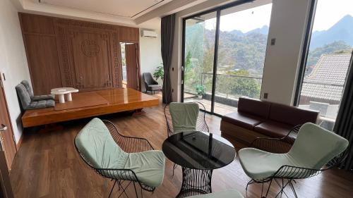 a living room with a table and chairs and a couch at Lotus Premium Lodge - Lotus Group Tours in Ha Giang