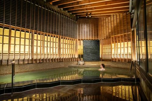 a woman in a swimming pool in a building at Hakodate Hotel Banso in Hakodate