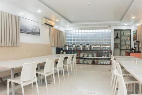 a dining room with white tables and white chairs at The New View by Ecotel - Cebu in Cebu City