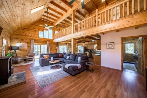 ein Wohnzimmer mit Sofa und Tisch in der Unterkunft Spacious Cozy Cabin Retreat on 5-Acres with HotTub in Elden Pueblo