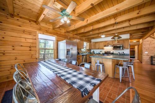 ein Esszimmer mit Tisch und eine Küche in der Unterkunft Spacious Cozy Cabin Retreat on 5-Acres with HotTub in Elden Pueblo