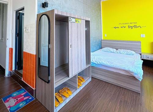 a room with a bedroom with a bed and a mirror at NA NI in Da Lat