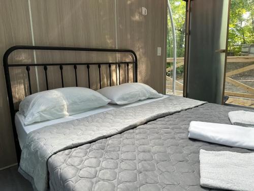 a large bed with white pillows on top of it at 2-bedroom Capsule House #30 in Parry Sound