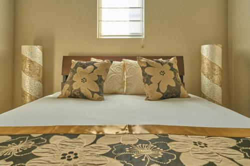 a bedroom with a large white bed with pillows at VILLA SENSE kujukuri in Kujukuri