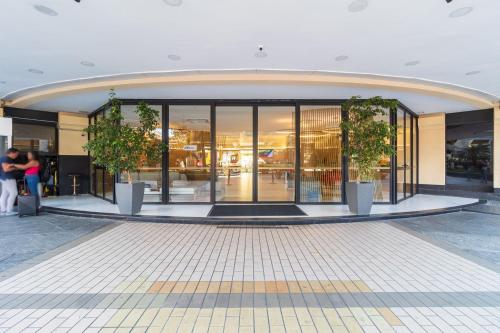 a building with two potted plants in front of it at LFlats no Hotel Aeroporto Congonhas in Sao Paulo