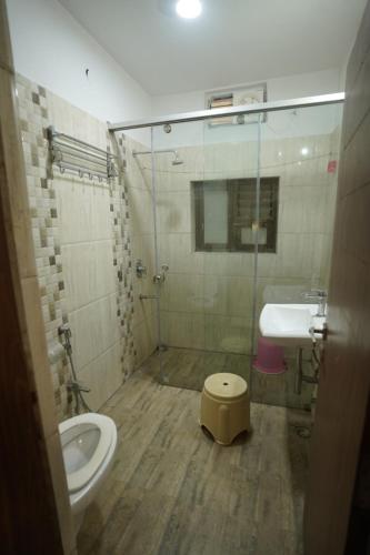 a bathroom with a shower and a toilet and a sink at Narmada vatika in Jabalpur