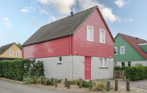 a red and white house with two green houses at Stunning Home In Wemeldinge With Sauna in Wemeldinge