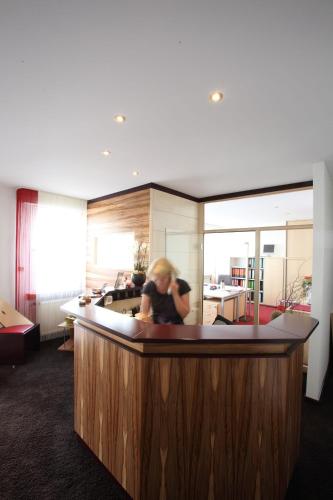 a woman standing at a counter in a room at Hotel Elysee in Seligenstadt