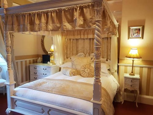 1 dormitorio con cama con dosel en AmarAgua Guest house, en Edimburgo