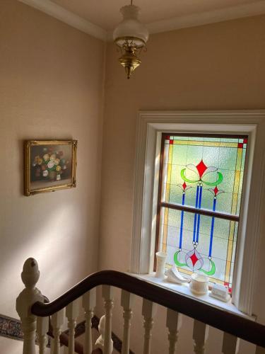 a staircase with a window with a stained glass at Country Mill House in Lawrencetown