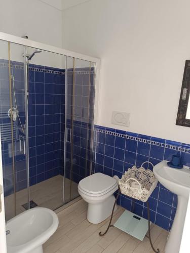 a blue tiled bathroom with a toilet and a sink at Love in Blue - La Terrazza di Positano in Positano