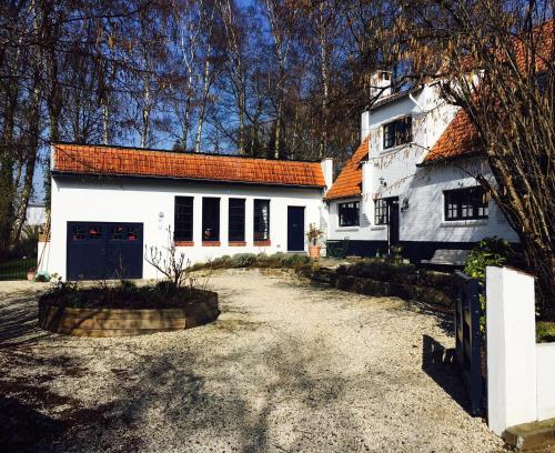 une maison blanche avec un toit orange et une allée. dans l'établissement Bed and Breakfast Ros & Marc, à Wezembeek-Oppem