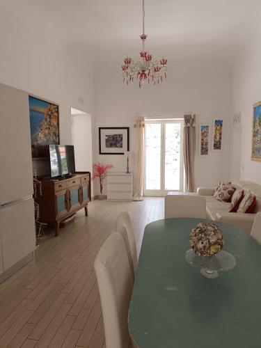 a living room with a table and a couch at Love in Blue - La Terrazza di Positano in Positano