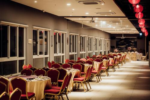 a row of tables and chairs in a dining room at TH Hotel in Pingtung City