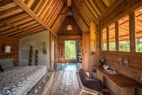 a bedroom with a bed and a ceiling fan at Desa Seni Baturiti in Baturiti